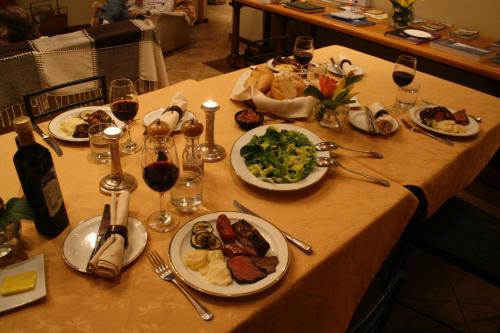 a table with plates of food and glasses of wine at Tumuñan Lodge in El Llano