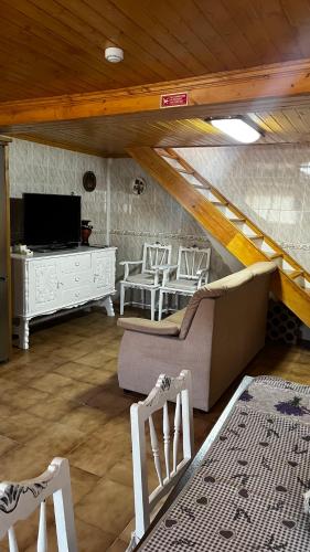 a living room with a couch and a tv at Casa da Ti Cristina in Pomares