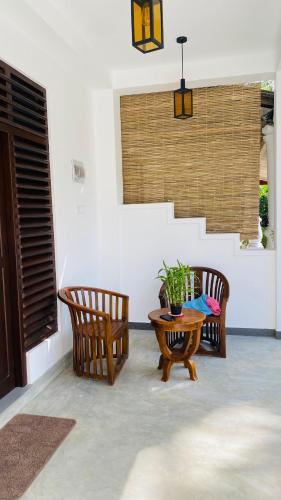 a living room with two chairs and a table at Sunset Villa in Unawatuna