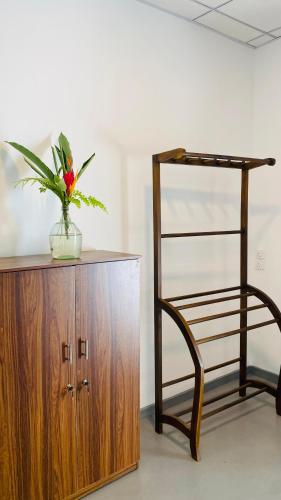 a plant in a vase on top of a wooden cabinet at Sunset Villa in Unawatuna
