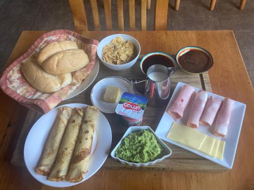 a table with plates of food and bread and dips at Tumuñan Lodge in El Llano