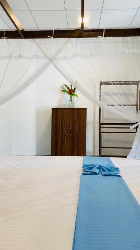 a bedroom with a white bed and a vase of flowers at Sunset Villa in Unawatuna