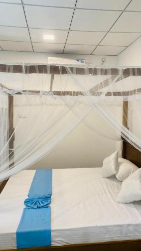 a bedroom with a bed with a mosquito net at Sunset Villa in Unawatuna