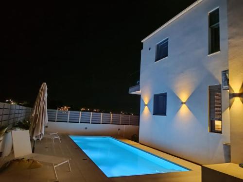 a swimming pool on the roof of a house at night at Blue View Suites in Chorafakia