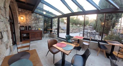 une véranda avec des tables et des chaises ainsi qu'une grande fenêtre dans l'établissement Villa Arca, aux Arcs-sur-Argens