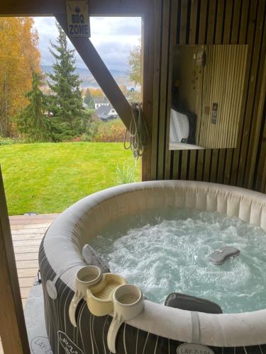 a jacuzzi tub in a room with a window at Bingo apartaments in Hønefoss