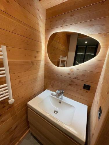 une salle de bain avec un lavabo blanc et un miroir dans l'établissement Chalet la petite ourse 110 m2 plein centre, à Villarembert