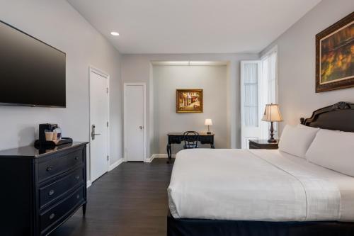 a bedroom with a bed and a flat screen tv at Chateau Hotel in New Orleans
