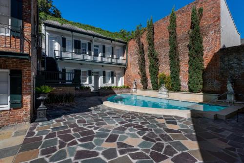 a courtyard with a swimming pool next to a brick wall at Chateau Hotel in New Orleans
