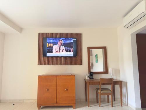 a tv on a wall in a room with a table at MESÓN DE LA RIVERA in San Juan Bautista Tuxtepec