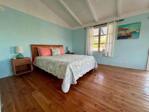 a bedroom with a bed with pink pillows and a window at Casa Kubler in Puerto Ayora