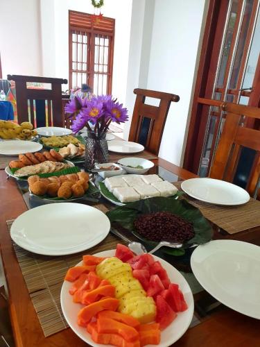 a wooden table with plates of food on it at Lanka Villa Mirissa in Mirissa