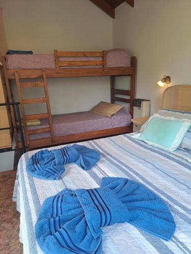 a bedroom with two bunk beds with blue towels on the bed at Pa-kuas del Uritorco in Capilla del Monte