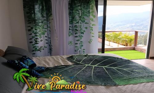 a bedroom with a large leaf pillow on a bed with a large window at VIVE PARADISE Hosteria Termal Mirador Only Adult in Medellín