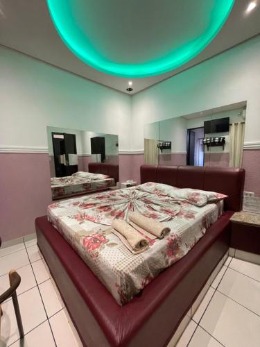 - un grand lit dans une chambre avec un grand miroir dans l'établissement Hotel Campo Limpo (Adults Only), à Campo Limpo