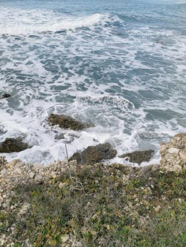 a view of the ocean with rocks and waves at Seasound in Agios Stefanos