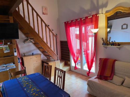 - un salon avec un canapé et des rideaux rouges dans l'établissement Au calme à Sanary, villaT2 climatisée pour 4 pers, à Sanary-sur-Mer