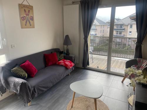 a living room with a couch and a table and a window at Charmant appartement in Saint-Gervais-les-Bains