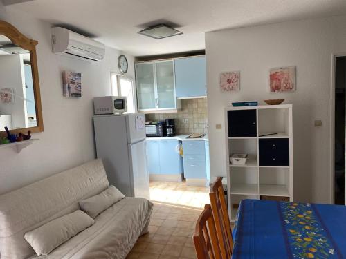 un salon avec un canapé et une cuisine dans l'établissement Au calme à Sanary, villaT2 climatisée pour 4 pers, à Sanary-sur-Mer