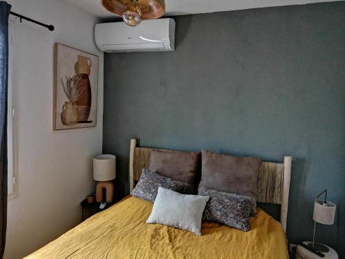 a bedroom with a bed with a yellow bedspread at L'Oliveraie in Nyons