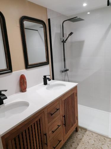 une salle de bain avec un lavabo, une douche et un miroir dans l'établissement L'Oliveraie, à Nyons