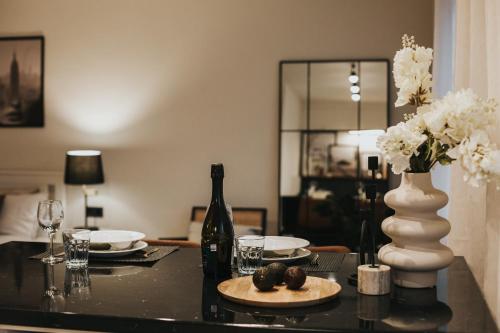 a table with a bottle of wine and a plate of food at Lacplesa Street Apartment in Daugavpils