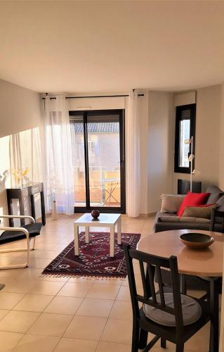 un salon avec un canapé et une table dans l'établissement Le Cèdre, appartement avec garage, à Vaison-la-Romaine