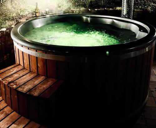 a jacuzzi tub with green water in it at Chata pod Cigerníkom in Matiašovce