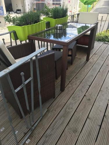a glass table and chairs on a wooden deck at Ferienhaus Störzel Wohnung B in Morbach