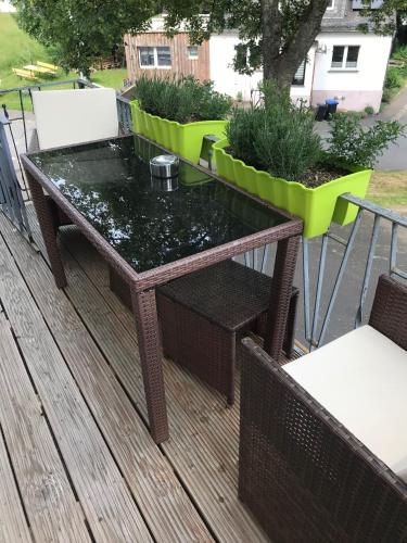 a glass table on top of a deck at Ferienhaus Störzel Wohnung B in Morbach