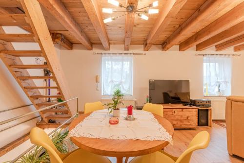 a living room with a table and yellow chairs at Ferienhaus Störzel Wohnung B in Morbach