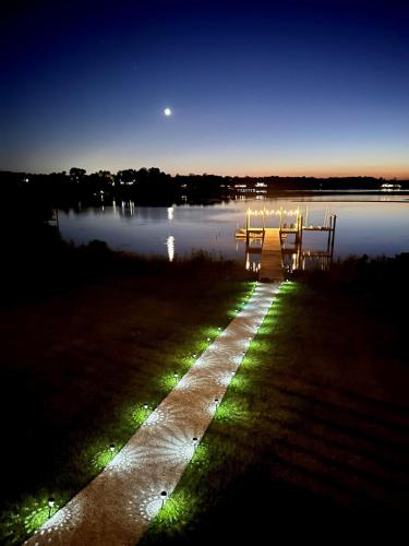 a couple of chairs sitting in the water at night at Exquisite 4-BR Boater's Paradise in Hampstead
