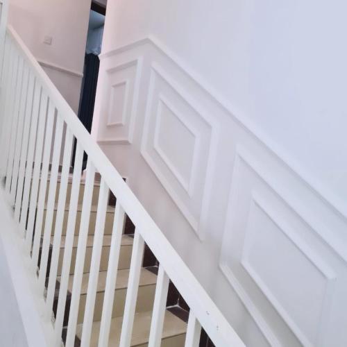a white staircase with white railings in a house at Sofitel Executive 4 bedrooms stand alone Milimani in Kisumu