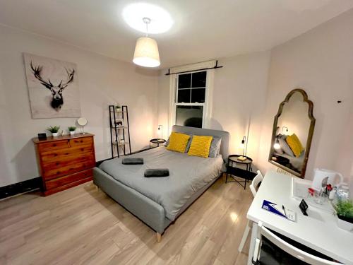 a bedroom with a bed and a dresser and a mirror at The Red Door House in London