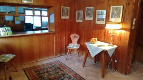a room with a table and a chair and a lamp at Alpengasthof Madlbauer in Bad Reichenhall