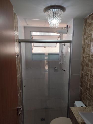 a bathroom with a shower and a chandelier at Apartamento CUESTA -TÉRREO - in Botucatu