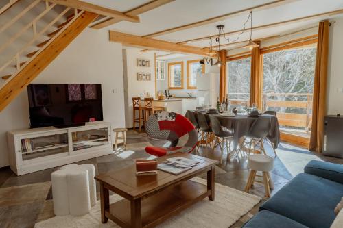 ein Wohnzimmer mit einem blauen Sofa und einem Tisch in der Unterkunft Hébergement 4 étoiles Accès Pied des Pistes en Navette Gratuite in Saint-Chaffrey