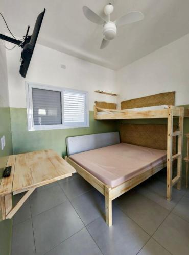a bedroom with two bunk beds and a fan at Chalés do Bona - Loft 14 in Ubatuba