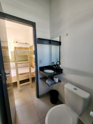 a bathroom with a toilet and a sink and a mirror at Chalés do Bona - Loft 14 in Ubatuba