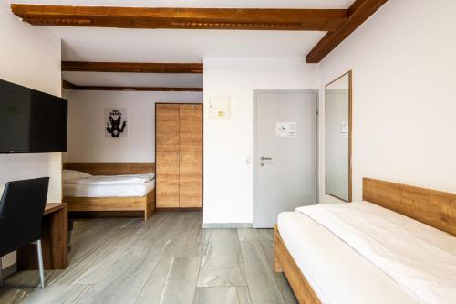 a bedroom with two beds and a desk at Wels Inn Hotel in Wels