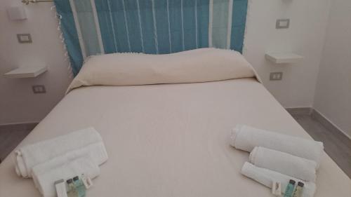 a white bed with two rolls of towels on it at Domu Loca in Pula