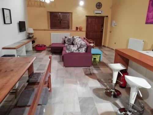 a living room with a purple couch and a table at Casa Villarmayor in Villarmayor
