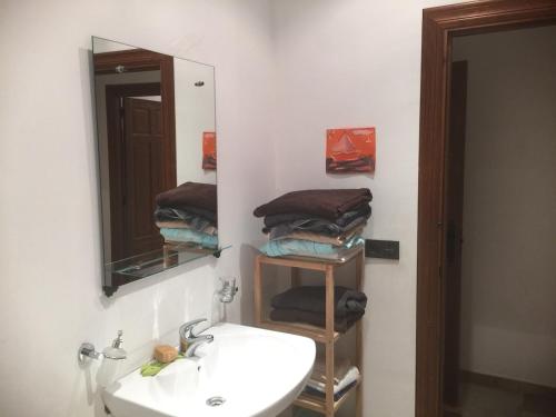 a bathroom with a sink and a mirror and towels at Casa Villarmayor in Villarmayor