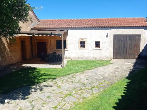 a house with a patio and a grass yard at Casa Villarmayor in Villarmayor