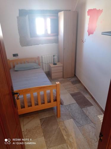 a small bedroom with a bed and a cabinet at Casa Villarmayor in Villarmayor