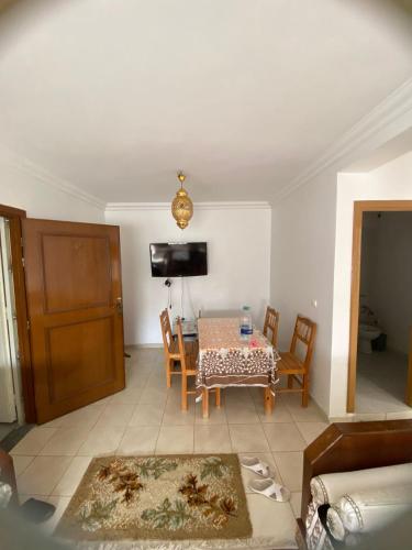 a living room with a table and chairs and a television at رياض طنجة مجمع الغابة الدبلوماسية قرية مستشفى الجامعي محمد 6 in Daidatz