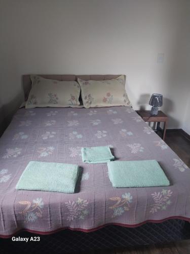 ein Bett mit zwei Handtüchern und zwei Kissen darauf in der Unterkunft Morada do sabiá in Resende