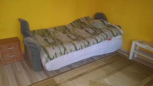 a bed in a corner of a room at Pokoje Goscinne Buzuki in Ciechanów