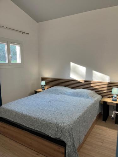 キュエールにあるLa girafeのベッドルーム1室(ベッド1台、ランプ2つ付きのデスク付)