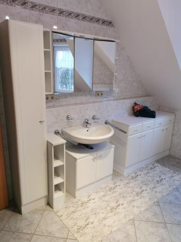 a white bathroom with a sink and a mirror at Lounge house in Burgau